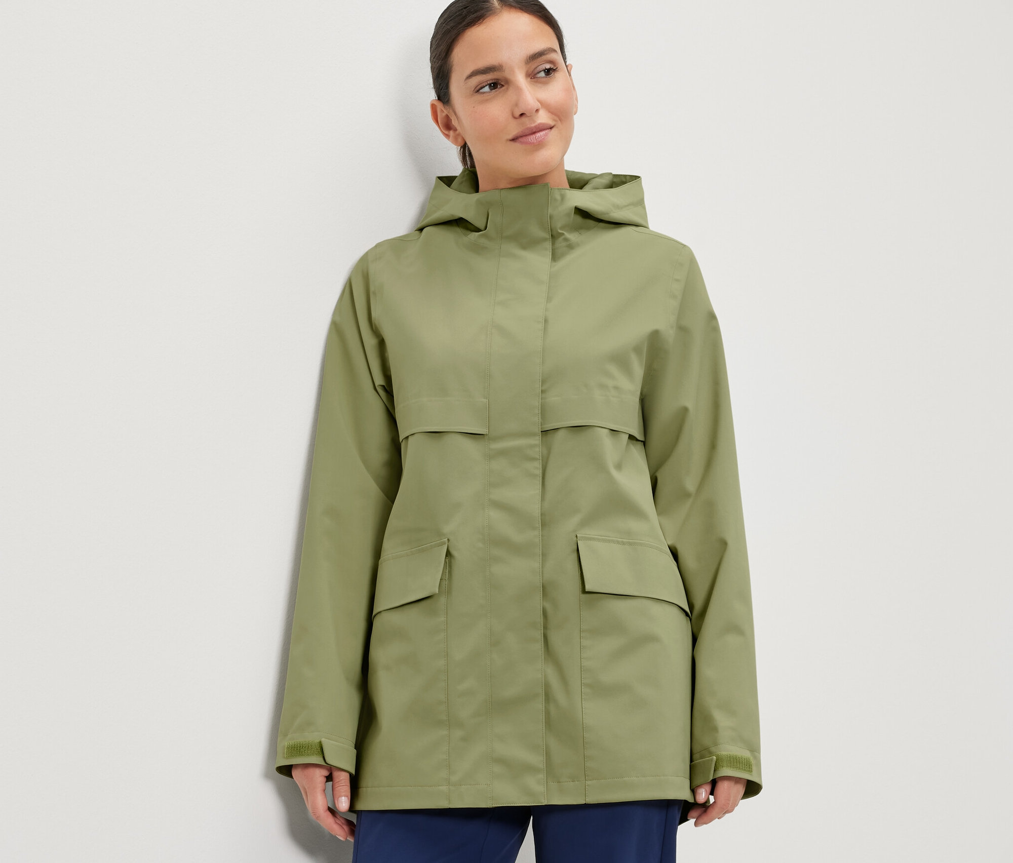 Žena má na sobě bundu do deště.