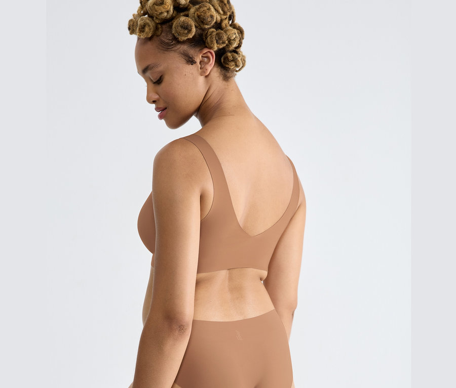 Žena má na sobě braletku sloggi ZERO Feel 2.0 Bralette v nostalgické hnědé barvě.