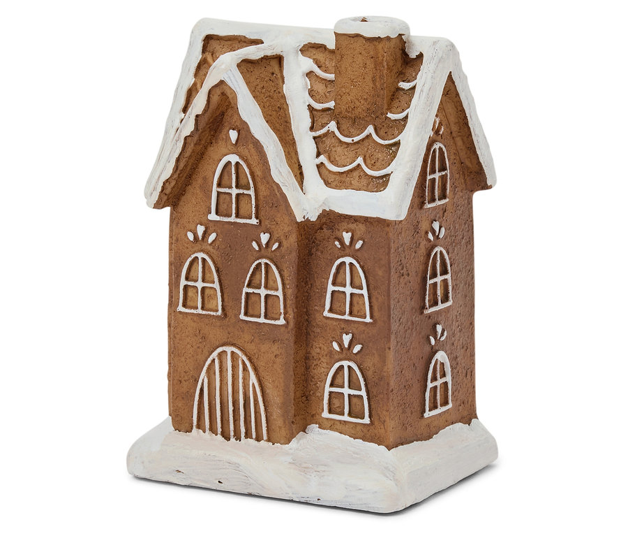 Detailní záběr na hnědý perníkový domeček s bílou polevou na okně a střeše.