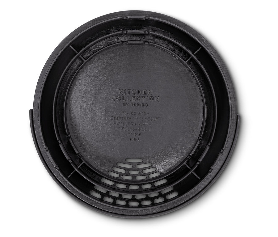 Detailní pohled shora na černý kuchyňský cedník s perforovaným dnem.