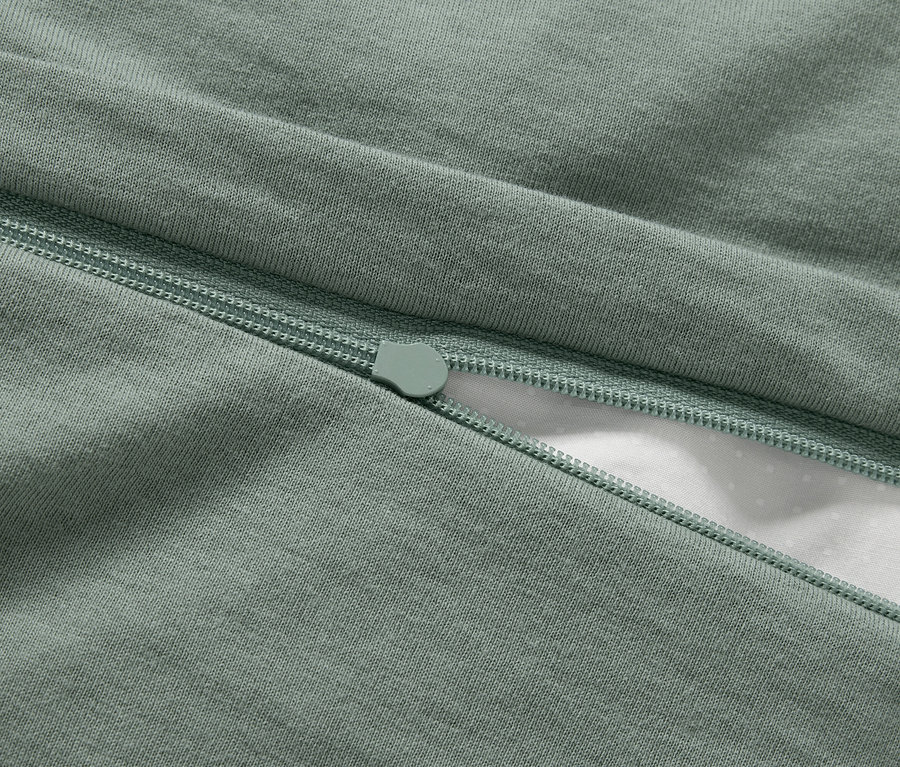 Detail zeleného povlečení se zipem.