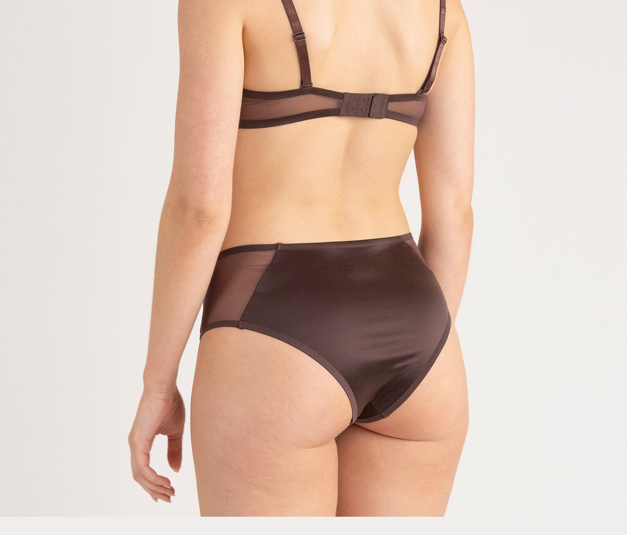 Žena zezadu v hnēdé podprsence a kalhotkách s vysokým pasem Passionata »Bianca«, dark chocolate.