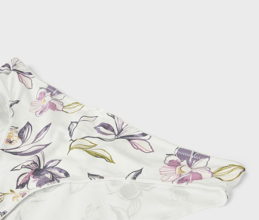 Detail bílého spodního prádla s květinovým vzorem.