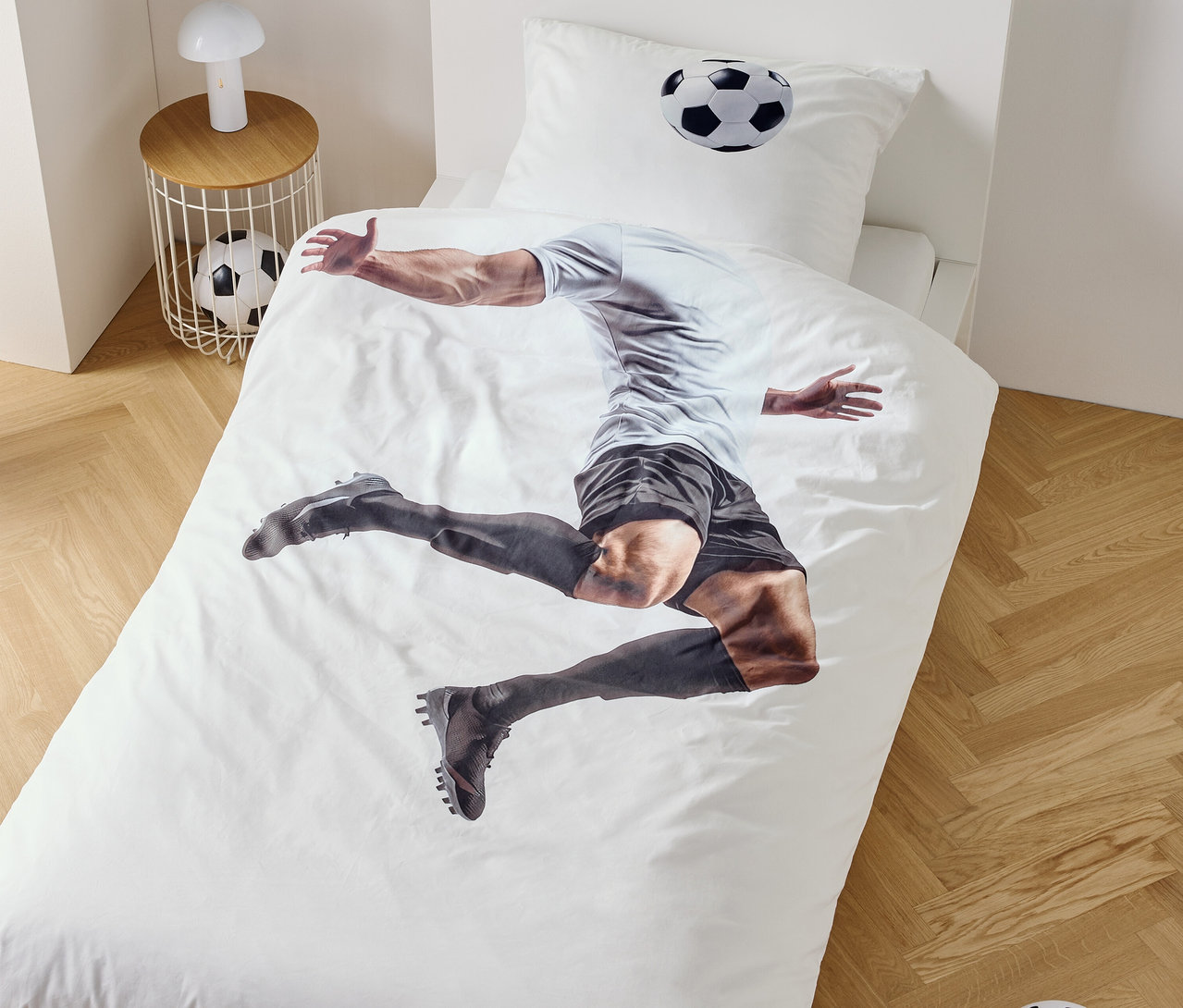 Na povlečení je zobrazen fotbalista ve skoku, vedle noční stolek s lampou a fotbalovým míčem.