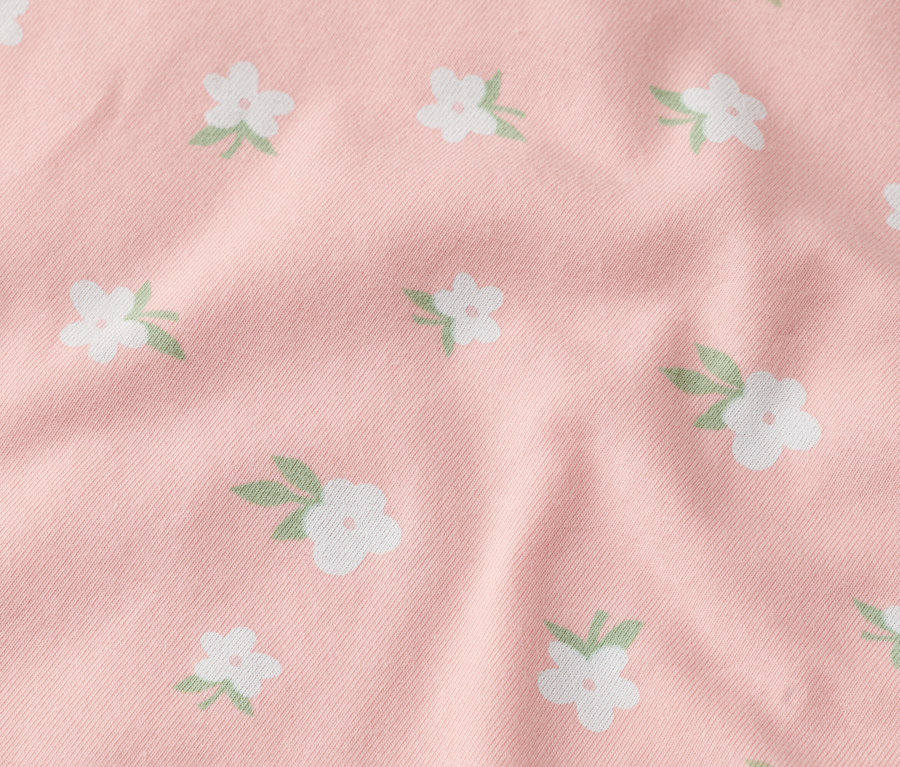Detail růžové látky s bílými květy.