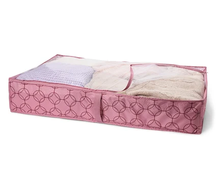 Růžový úložný box pod postel s geometrickým vzorem, vyplněný textiliemi, pod průhledným víkem.