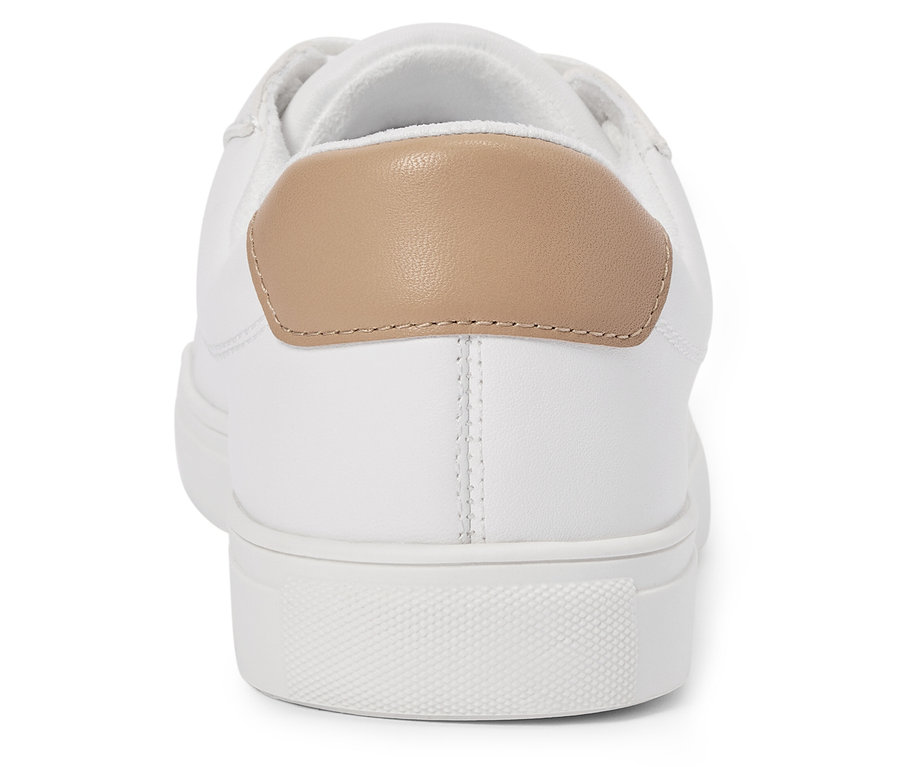 Pohled zezadu na bílé tenisky s béžovou patou.