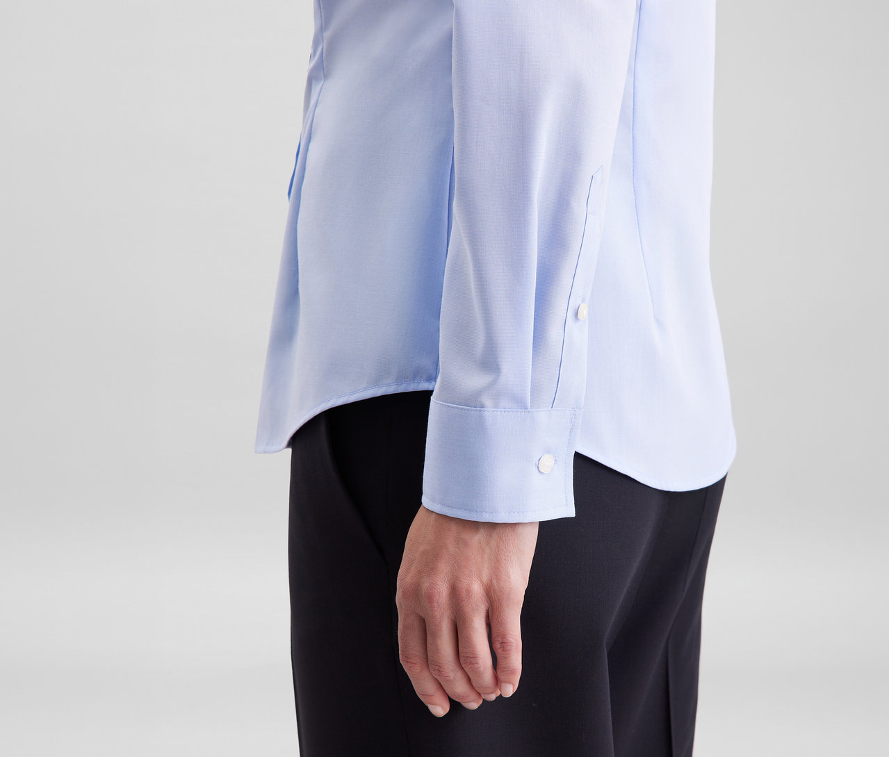 Osoba v světle modré halence slim fit non iron Seidensticker a černých kalhotách.