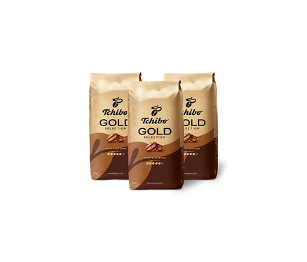 Tři balení kávy Tchibo Gold Selection stojí na bílém pozadí.