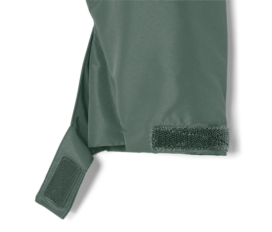 Detail zelené bundy do každého počasí se suchým zipem na rukávu.