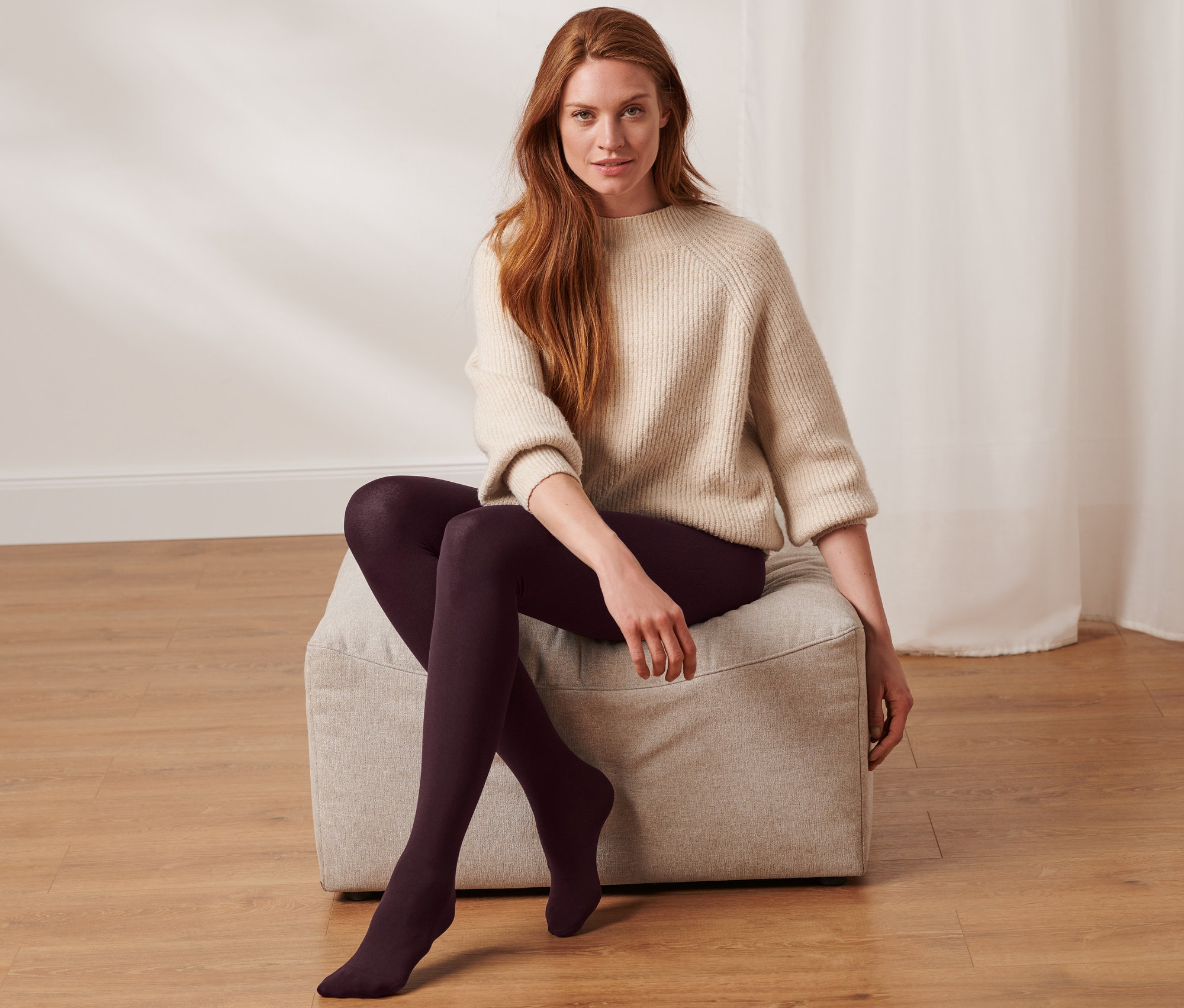 Žena sedí na taburetu a má na sobě termopunčocháče.