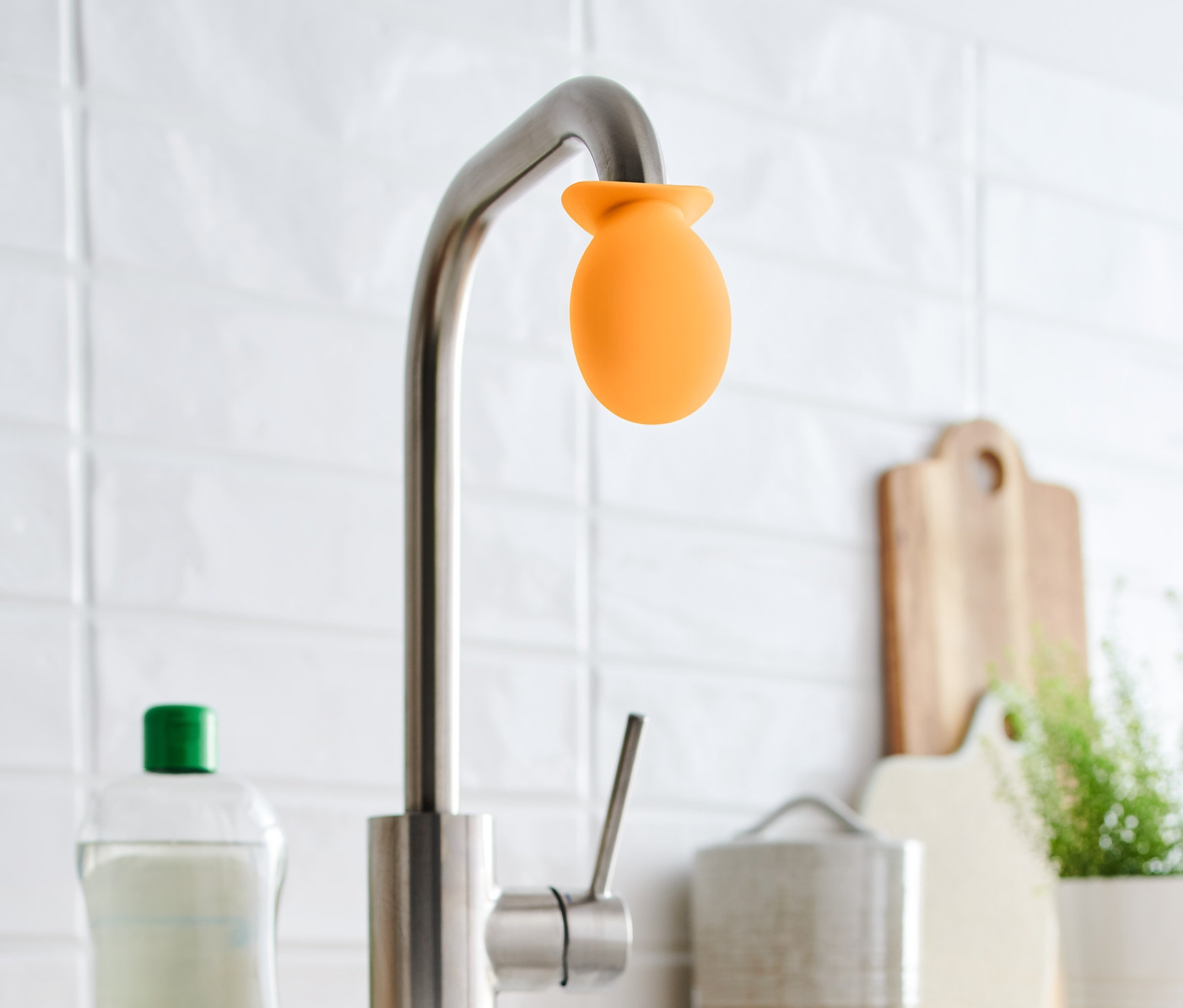 Na vodovodní kohoutek je nasazený oranžový odvápňovací nástavec.