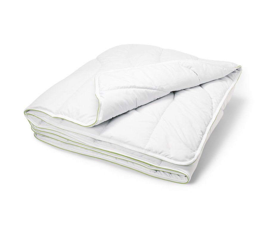 Složená bílá prošívaná přikrývka irisette® greenline s aktivním uhlím Dacron® se zeleným lemem.