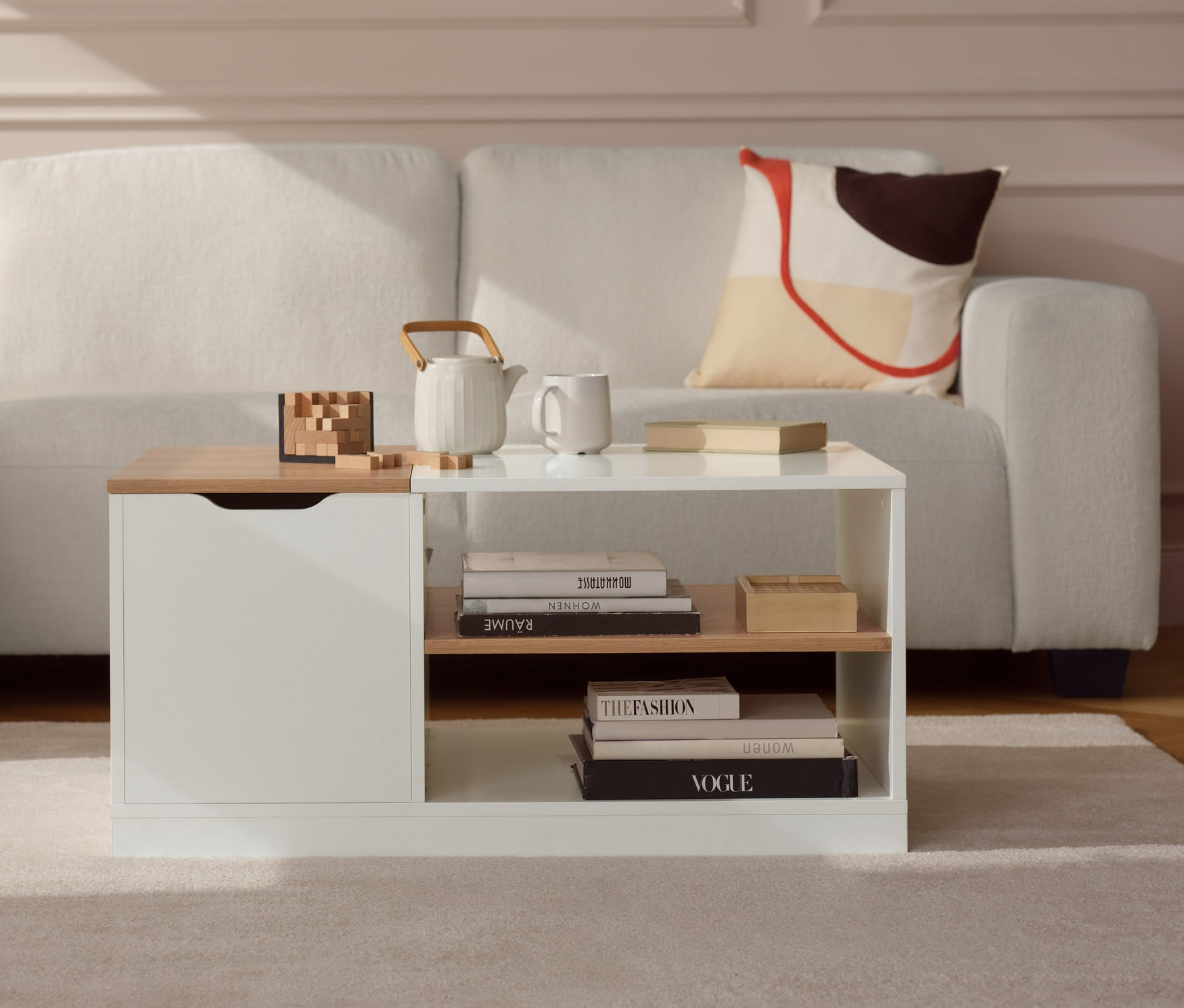 Krémová rohová pohovka vlevo a konferenční stolek se skrytými kolečky v obývacím pokoji.