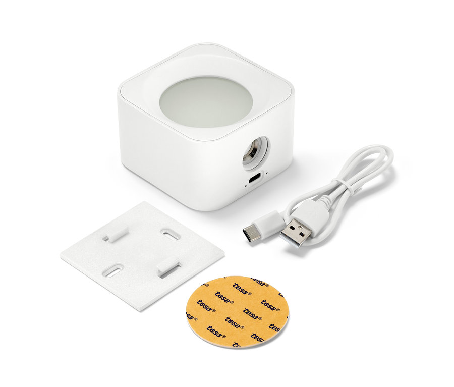 Bílé nástěnné bateriové LED svítidlo, montážní deska, nabíjecí kabel a lepicí podložka na bílém pozadí.