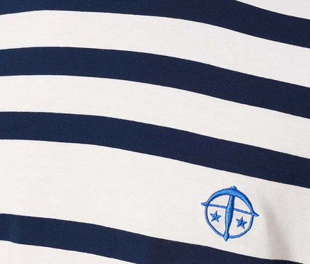 Detail muže v pruhovaném tričku s modrým logem.