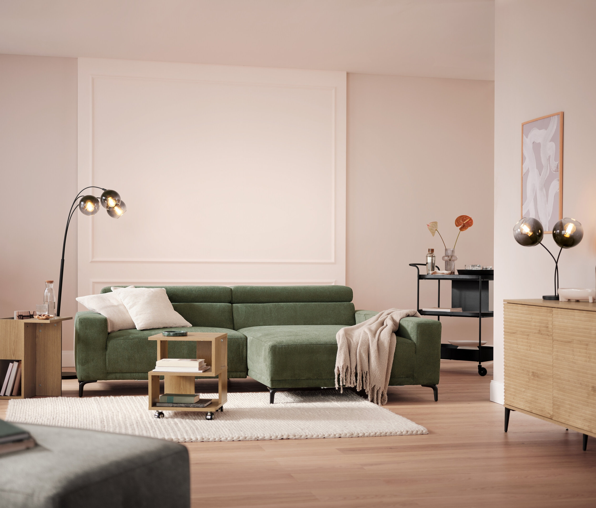 Obývací pokoj s pohovkou, lampou a servírovacím vozíkem.