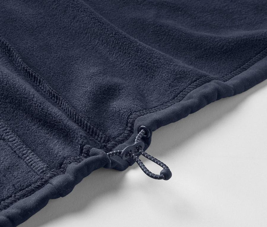 Detail modré fleecové bundy se zipem.
