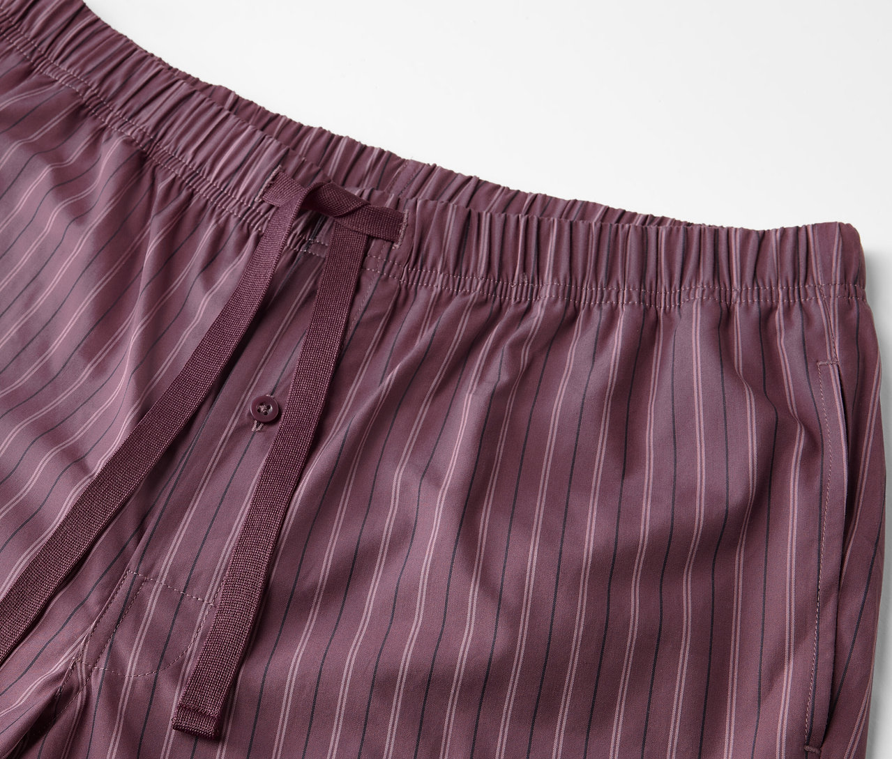 Detail bordó pyžamových kalhot s tkaným vzorem a stahovací šňůrkou.