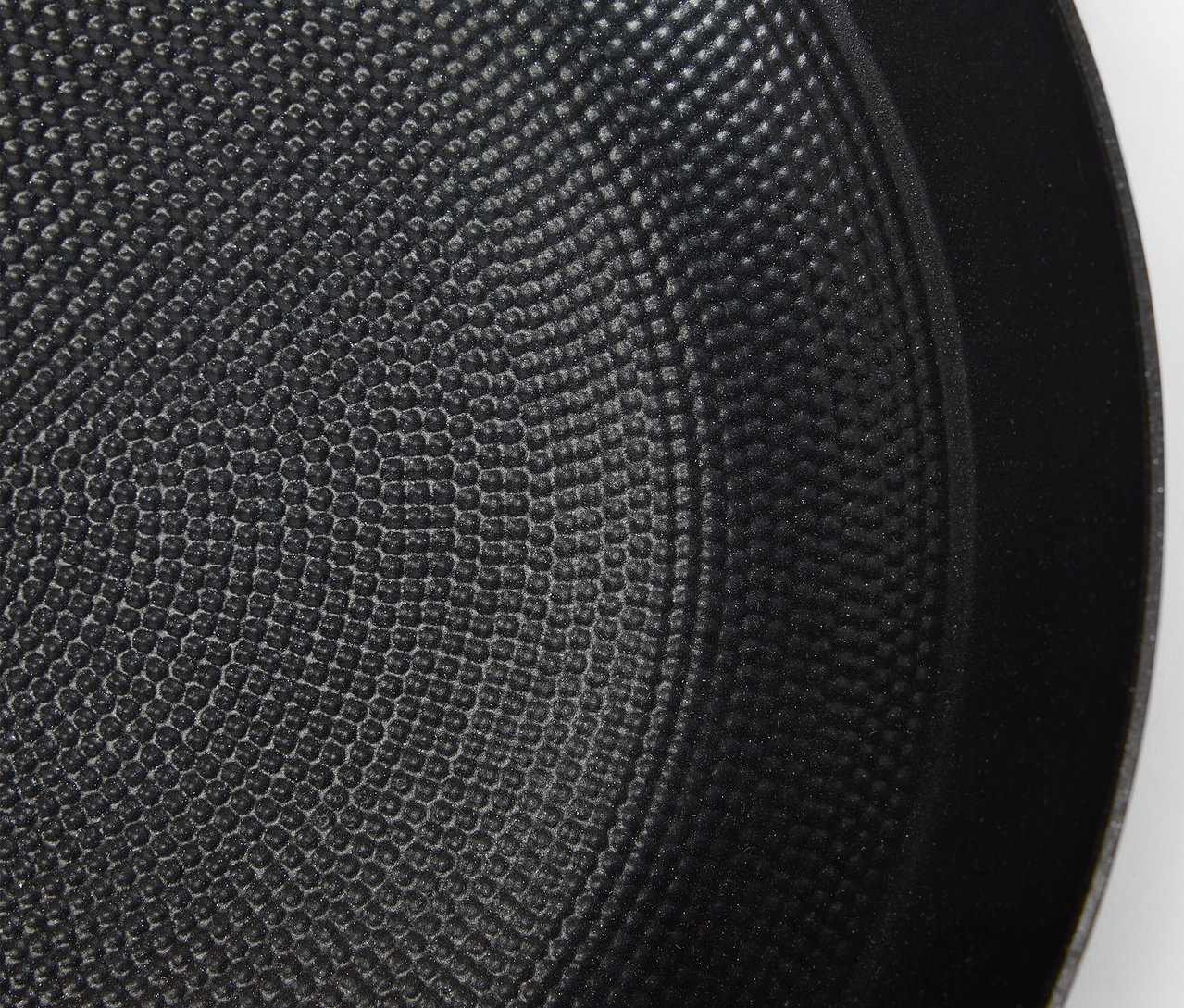 Detailní záběr na texturovaný povrch černé pánve.