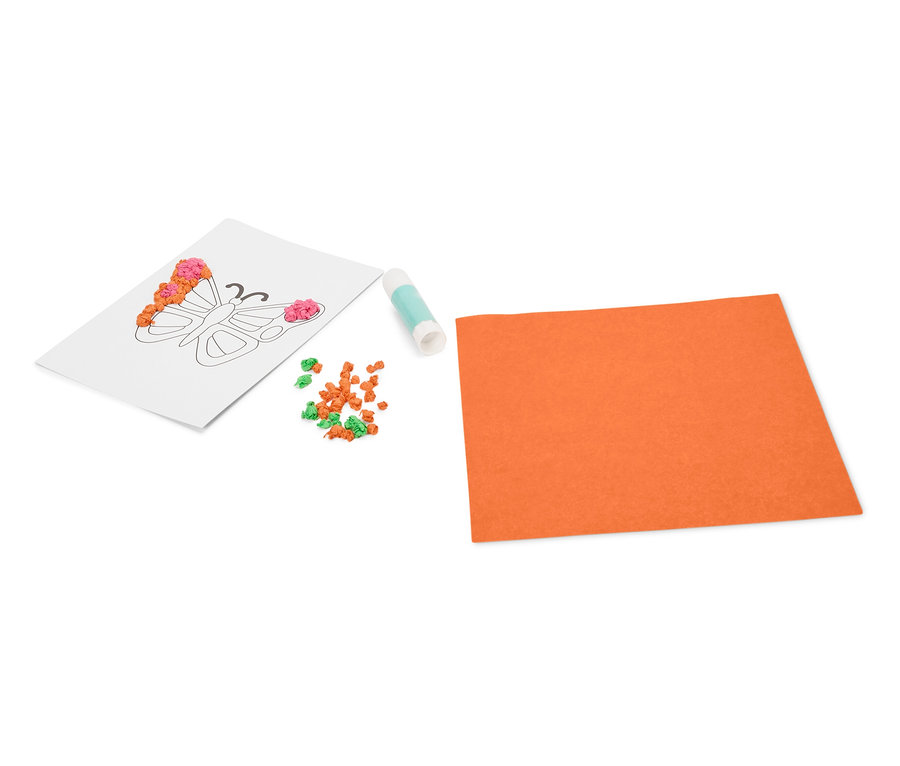 Na bílém pozadí leží omalovánka s motýlem, tuba lepidla, malé oranžové a zelené kuličky a oranžový list papíru.