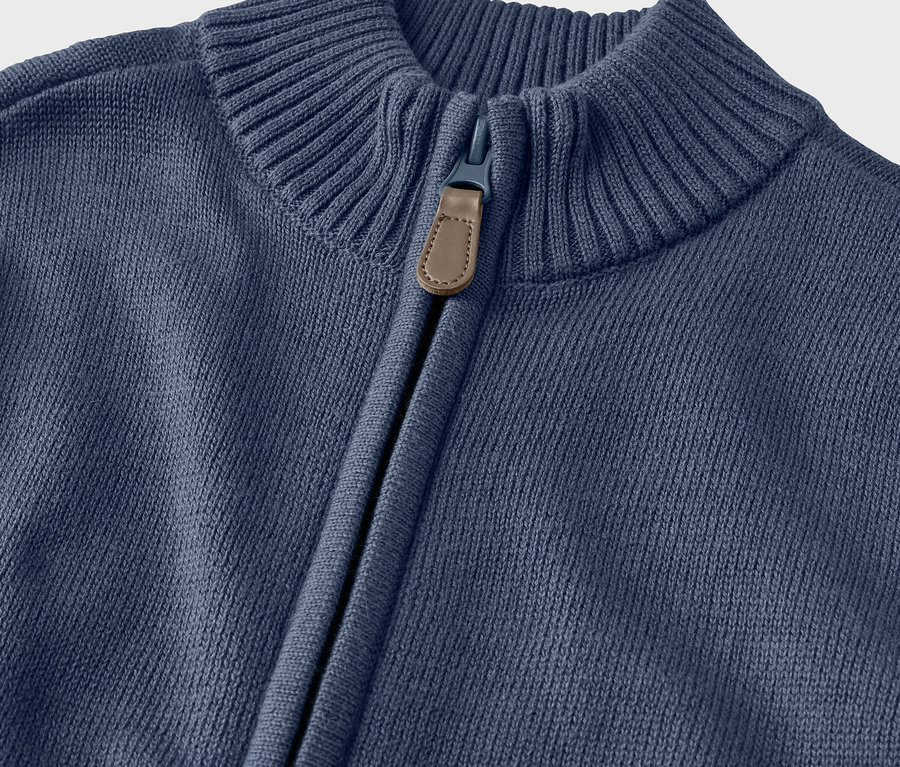 Detail dívčího pleteného svetru s límcem a zipem.