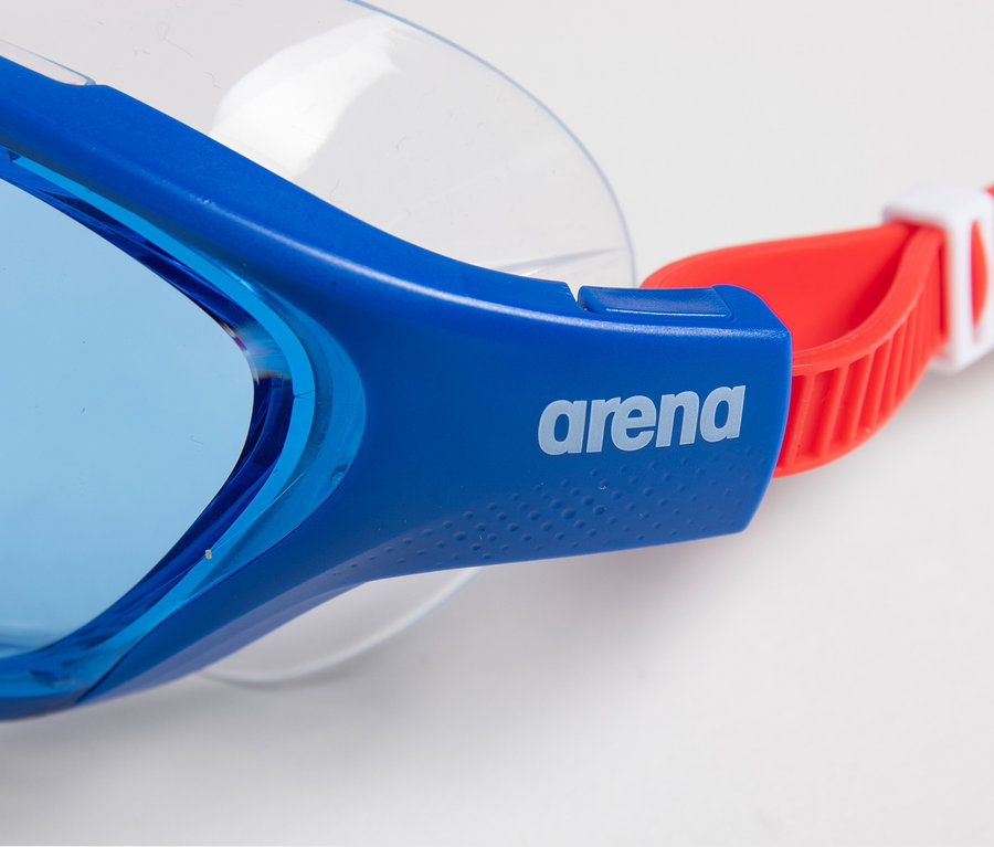 Detailní záběr modrých dětských plaveckých brýlí arena Junior The One Mask s červeným páskem na bílém pozadí.