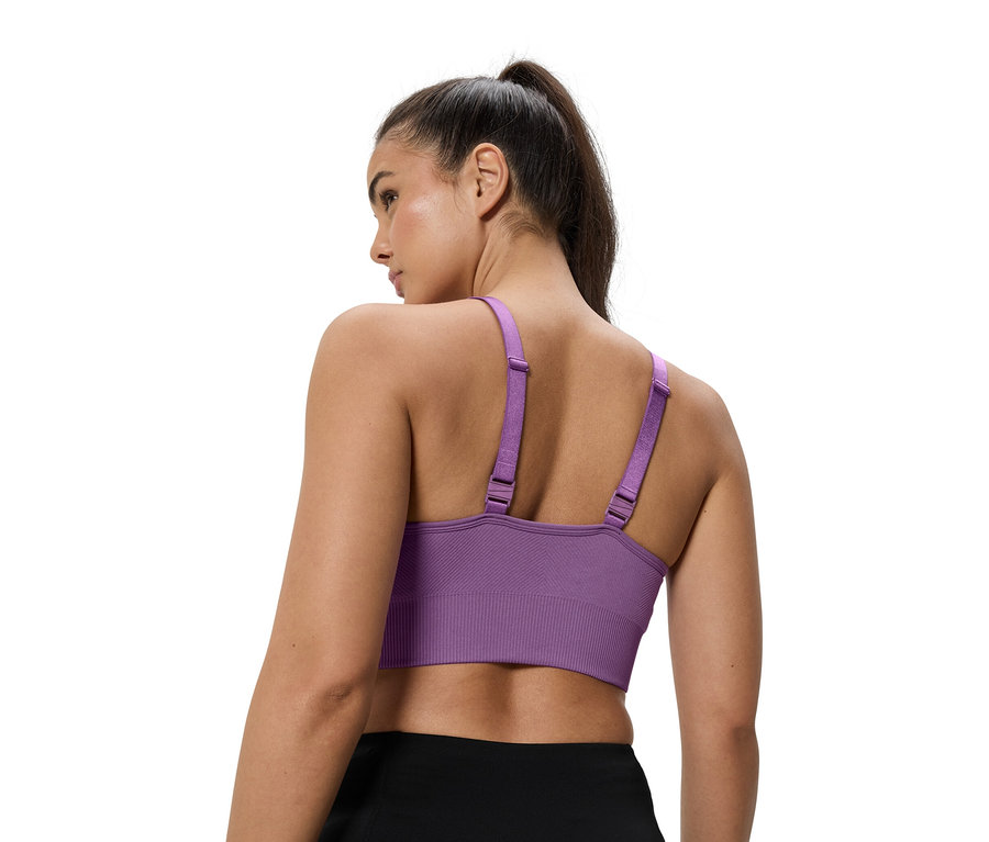 Zena ma na sobe fialovou sportovni podprsenku.