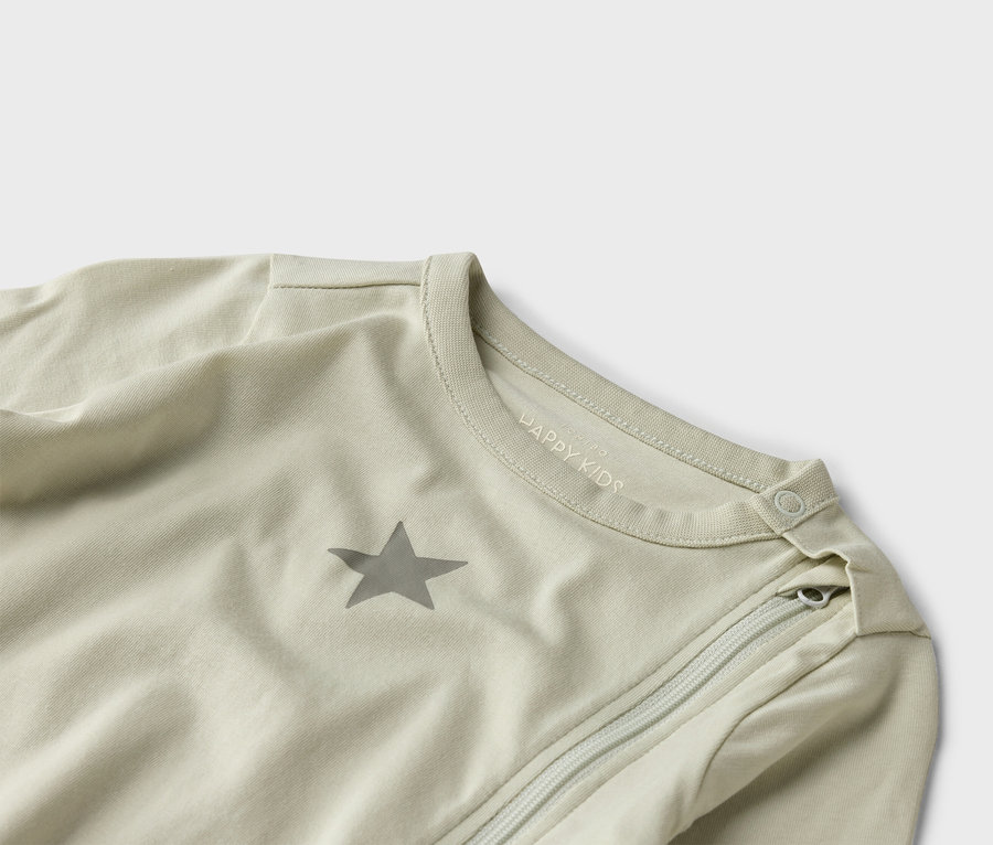 Detailní záběr na světle zelený dětský spací pytel se zipem a hvězdou