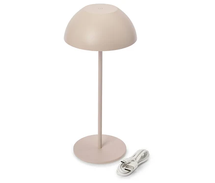 Béžová stolní lampa s kopulovitým stínidlem a nabíjecím kabelem na bílém pozadí.