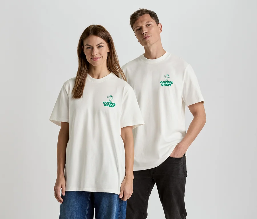 Žena a muž stojí vedle sebe a mají na sobě odpovídající trička s nápisem "Coffee Crew".