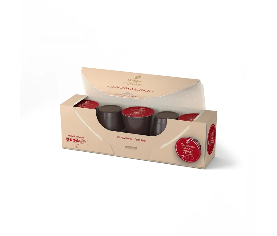 Otevřené balení Tchibo Cafissimo Flavoured Espresso Maple & Pecan, ukazující 10 tmavě hnědých kapslí s červenými víčky.
