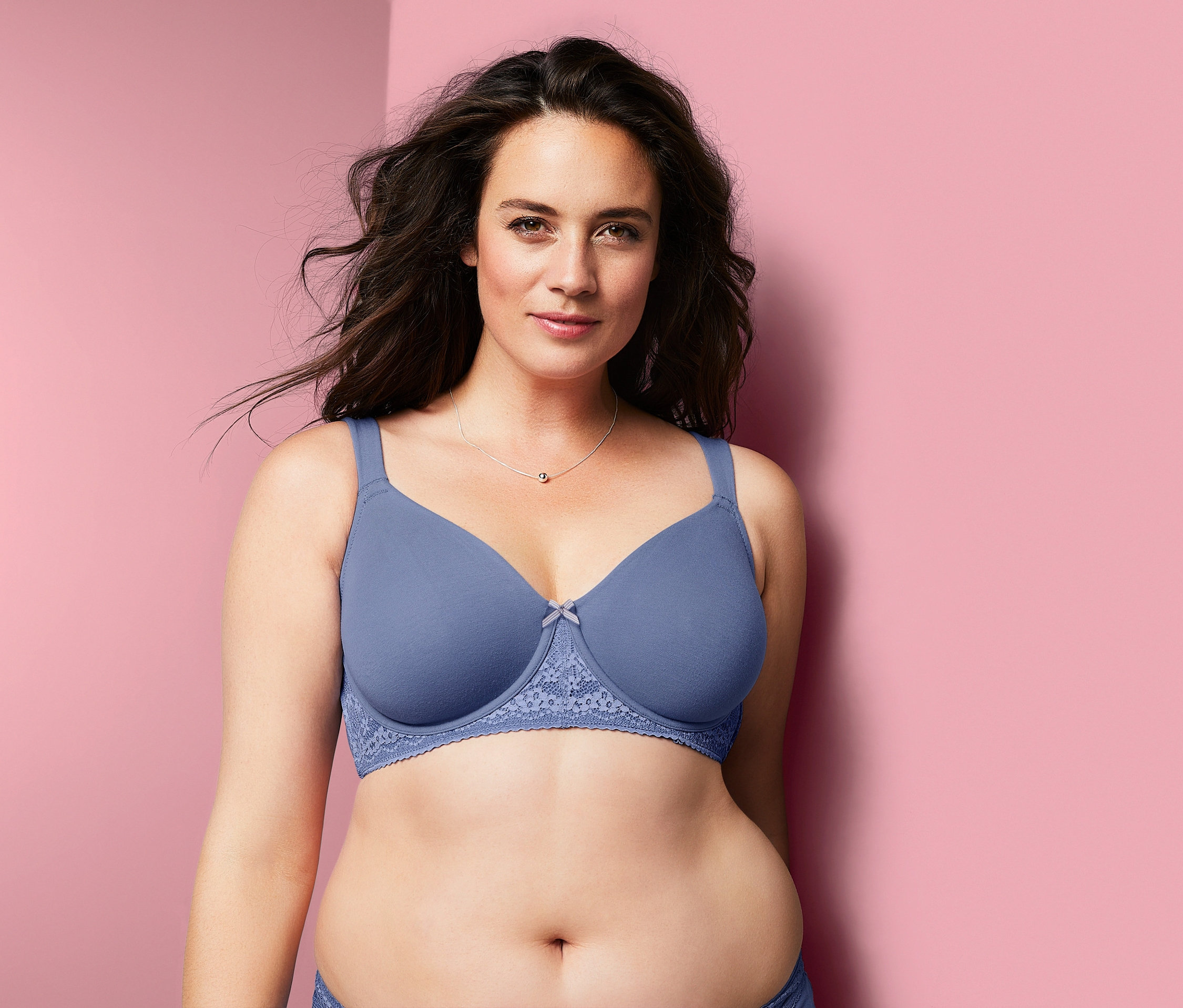 Žena má na sobě modrou podprsenku s kosticemi.