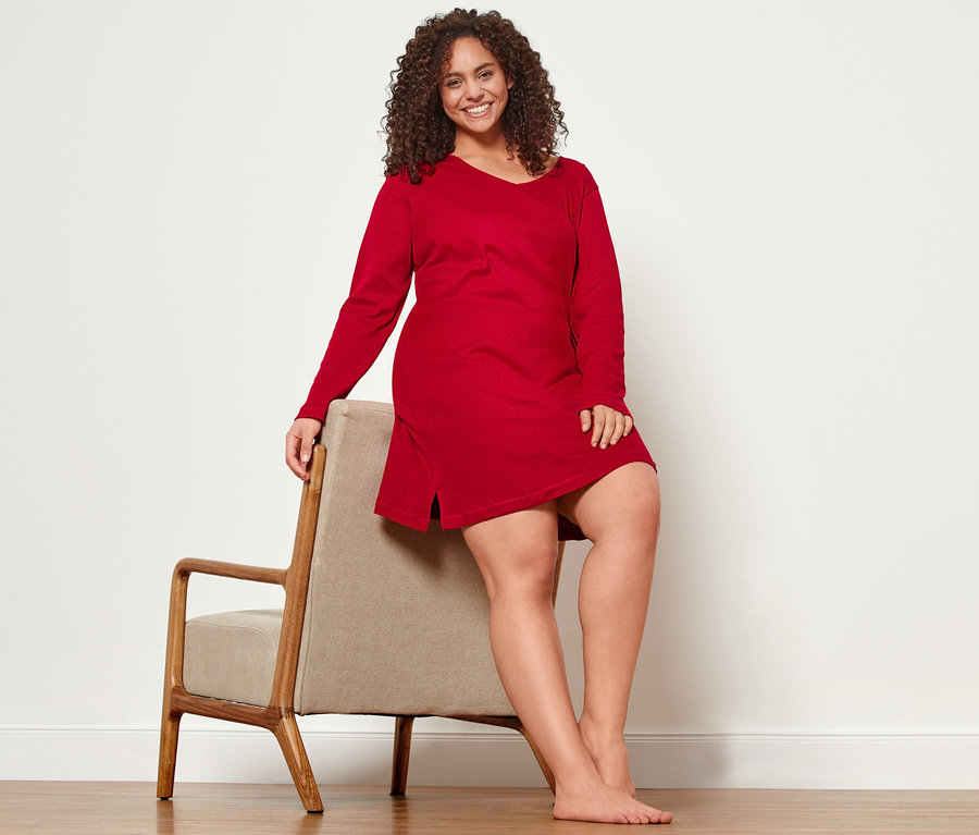 Žena sedí na židli v ažurové noční košili.