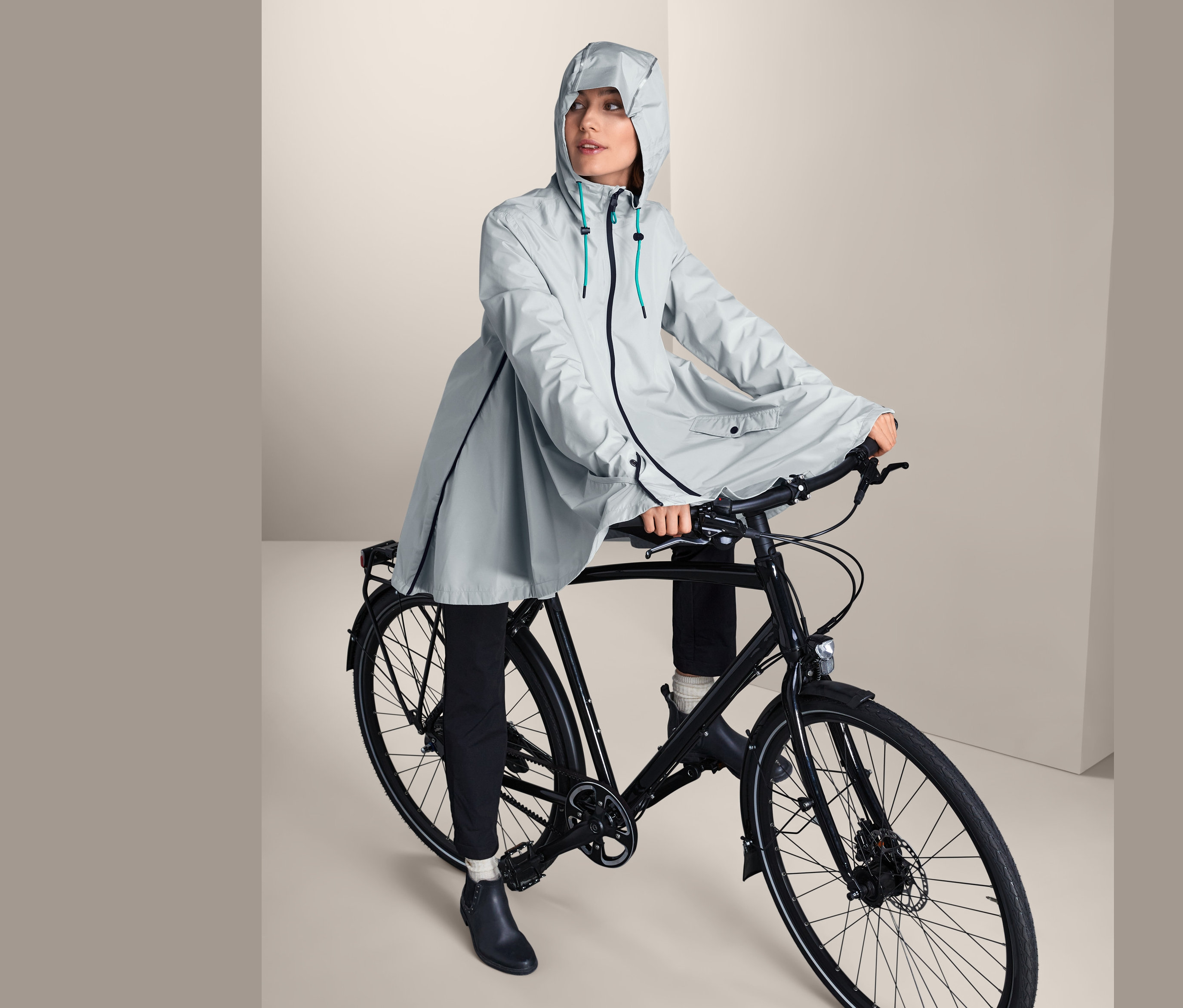 Žena na kole má na sobě pláštěnku.