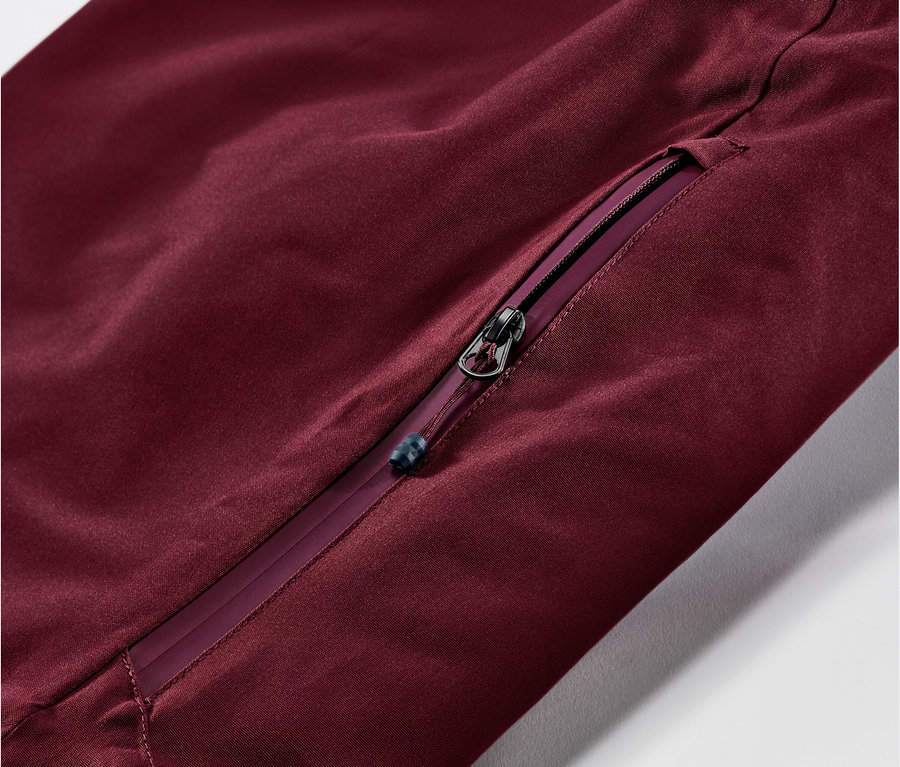 Detail vínově červených lyžařských kalhot se zipem.