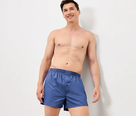 Muž opřený o zeď má na sobě modré tkané boxerky, 4 ks.
