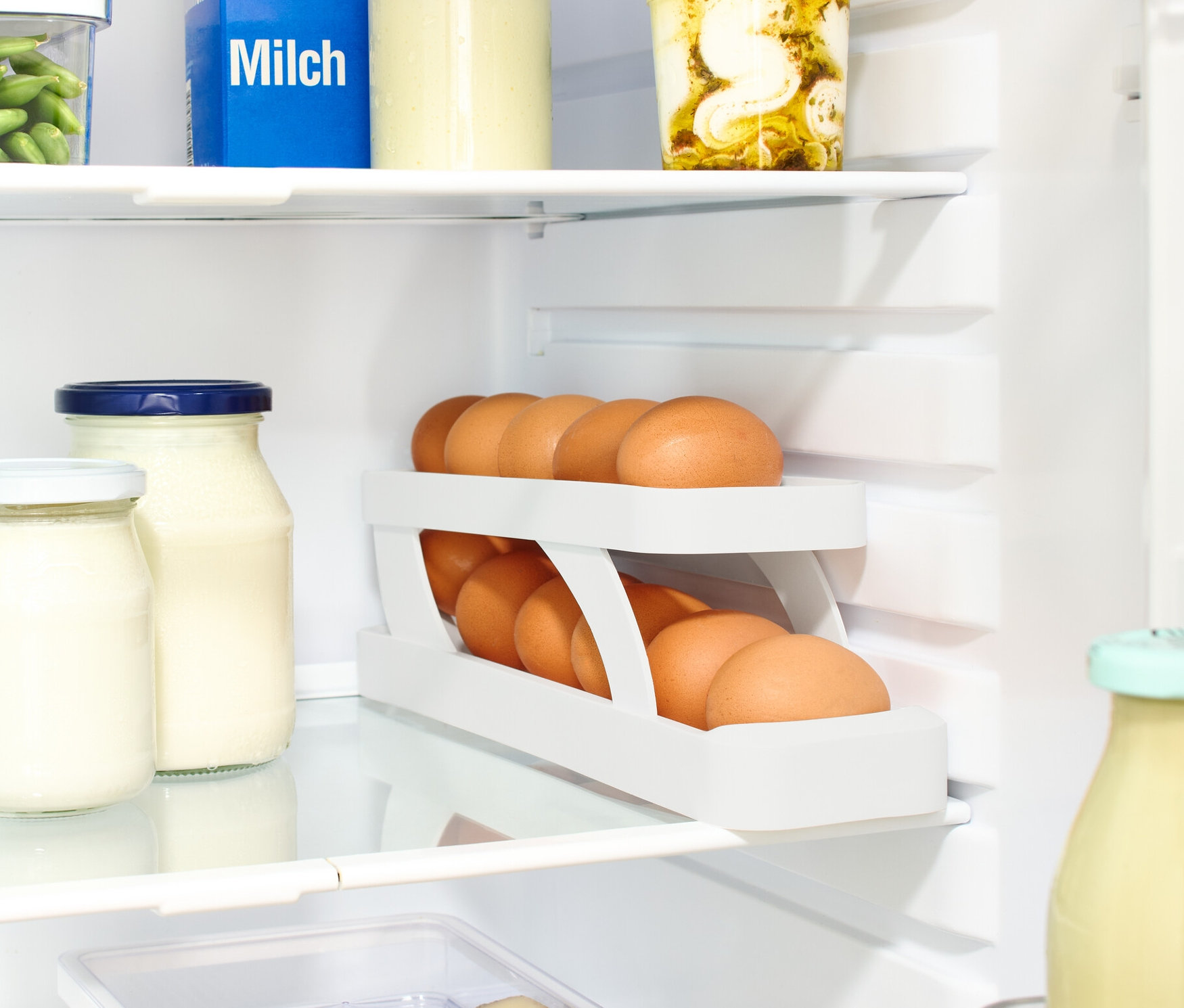 V lednici je mléko, sklenice a Stojan na vejce.