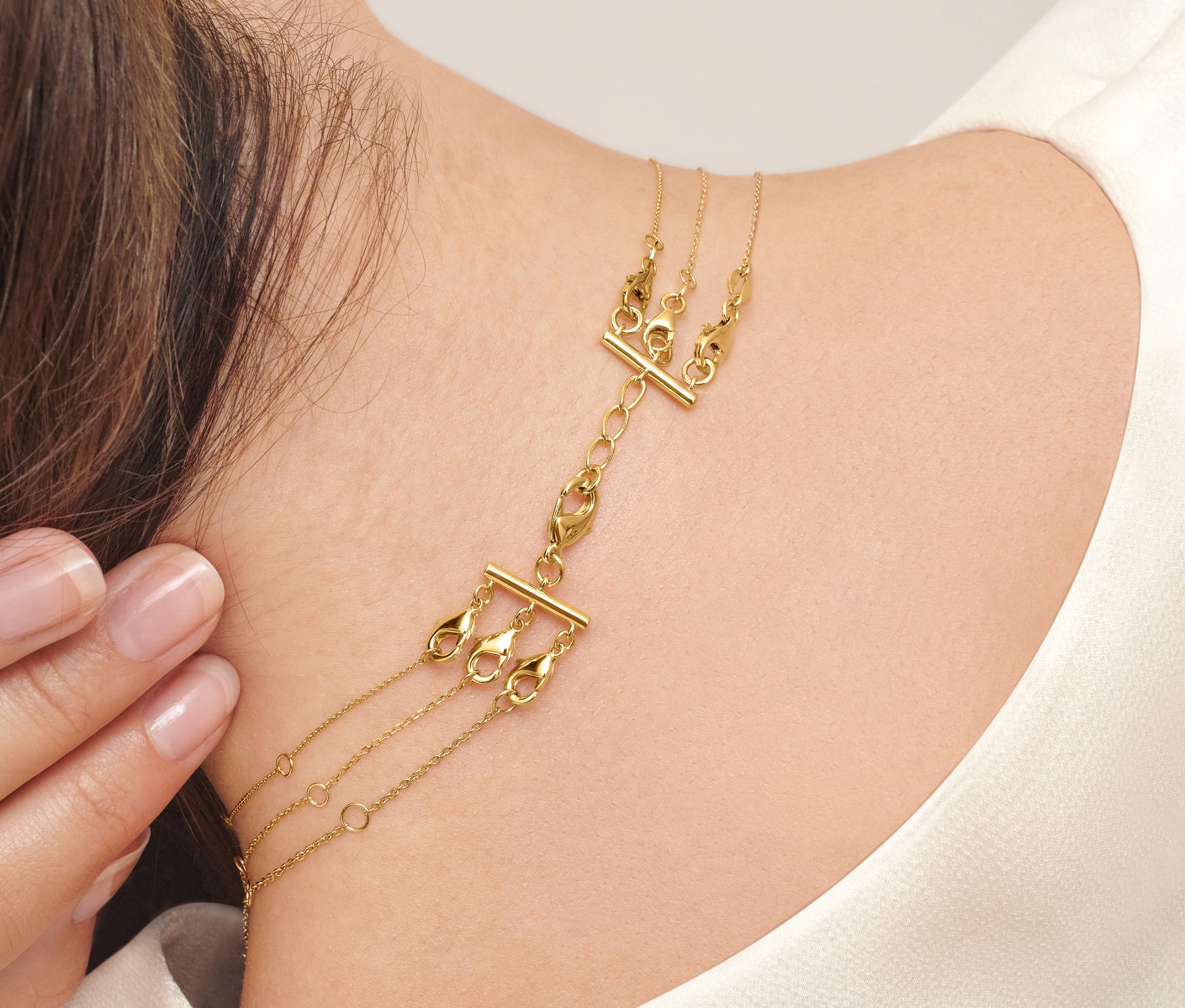 Žena nosí 2 ks řetízkového zapínání pro vrstvení.