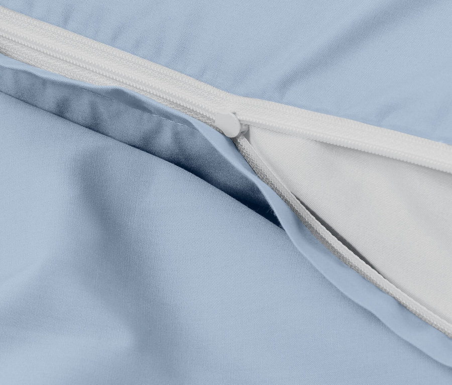 Detail světle modrého povlečení s bílým zipem.