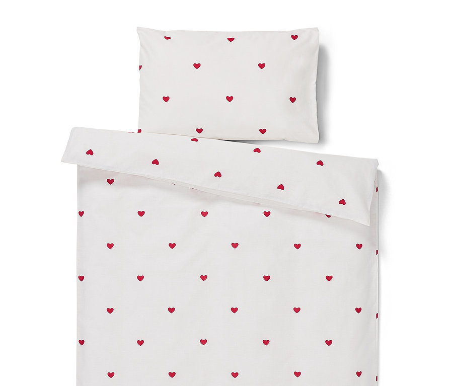 Bílé povlečení s červenými srdíčky.