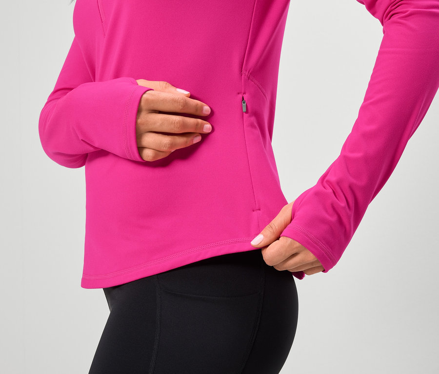 Žena má na sobě růžový top s dlouhým rukávem a černé legíny.