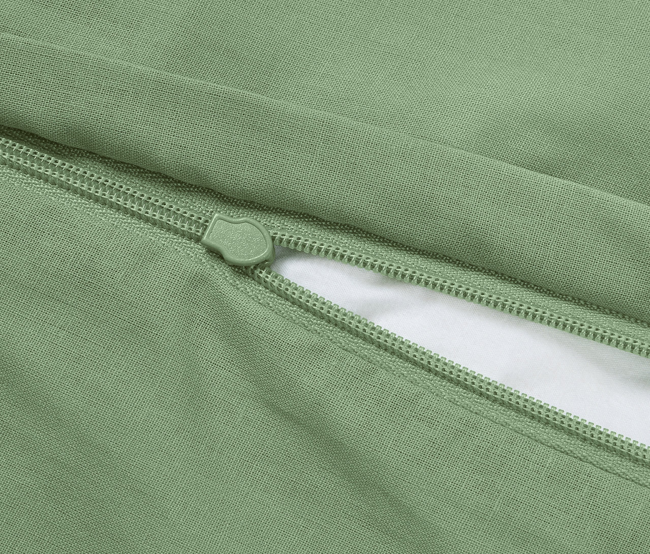 Detailní záběr na zelený povlak na polštář se zipem.