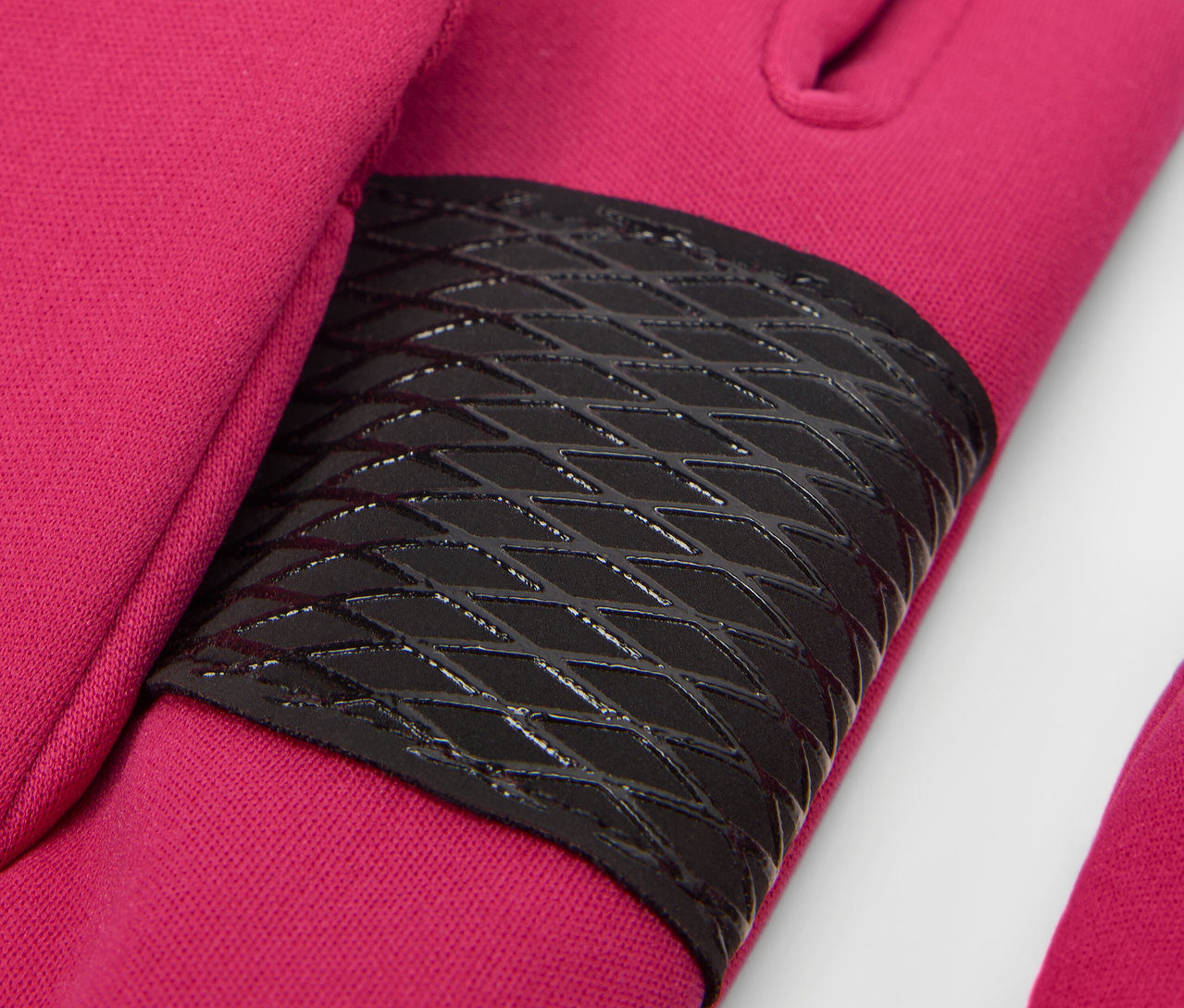 Detail dětských softshellových rukavic v bobulové barvě s černým protiskluzovým prvkem.