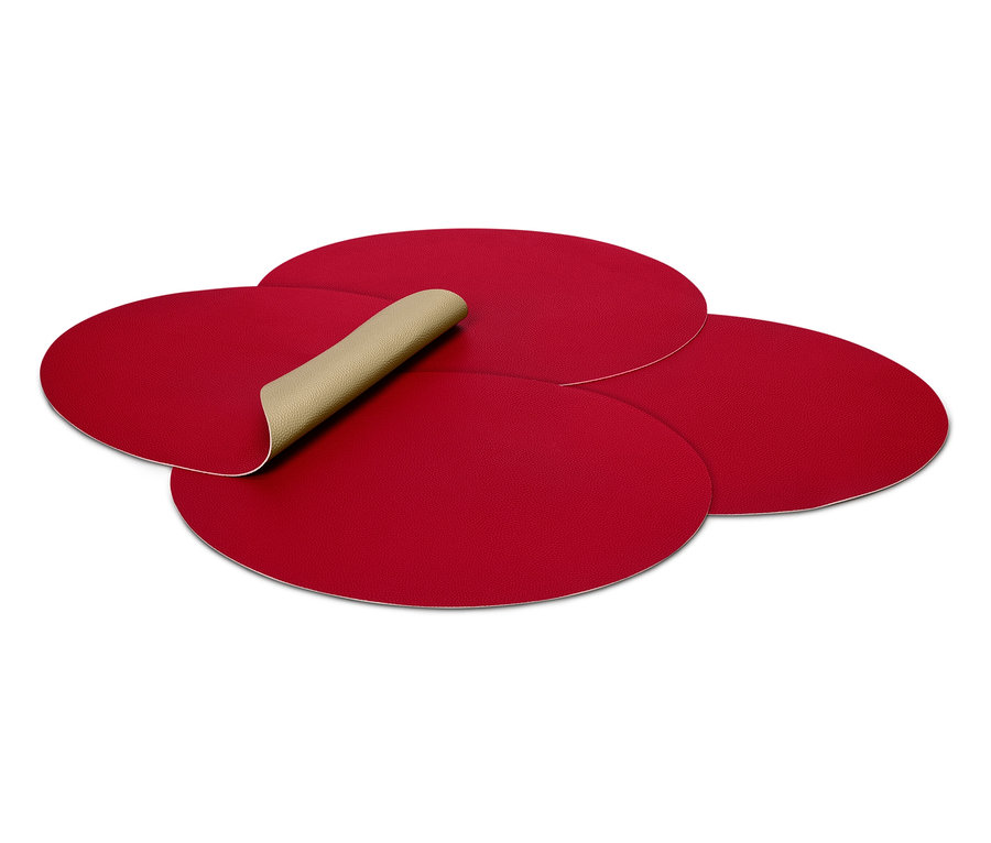 Čtyři červené prostírání, jedno z nich je otočené a ukazuje béžovou spodní stranu.