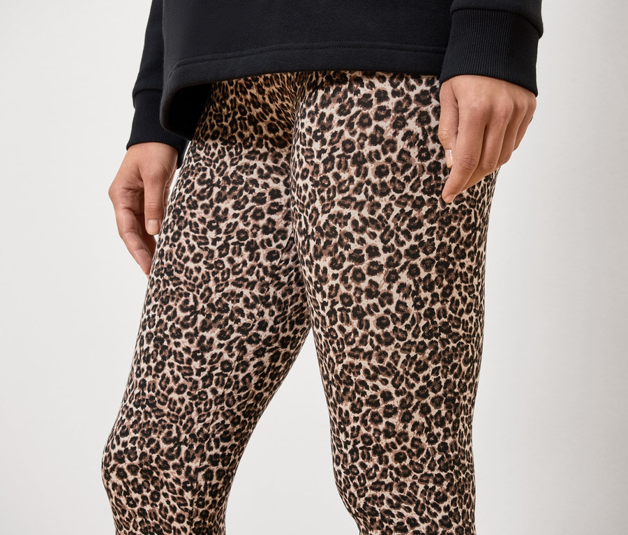 Neznámá osoba má na sobě černé tričko a legíny se zvířecím potiskem.