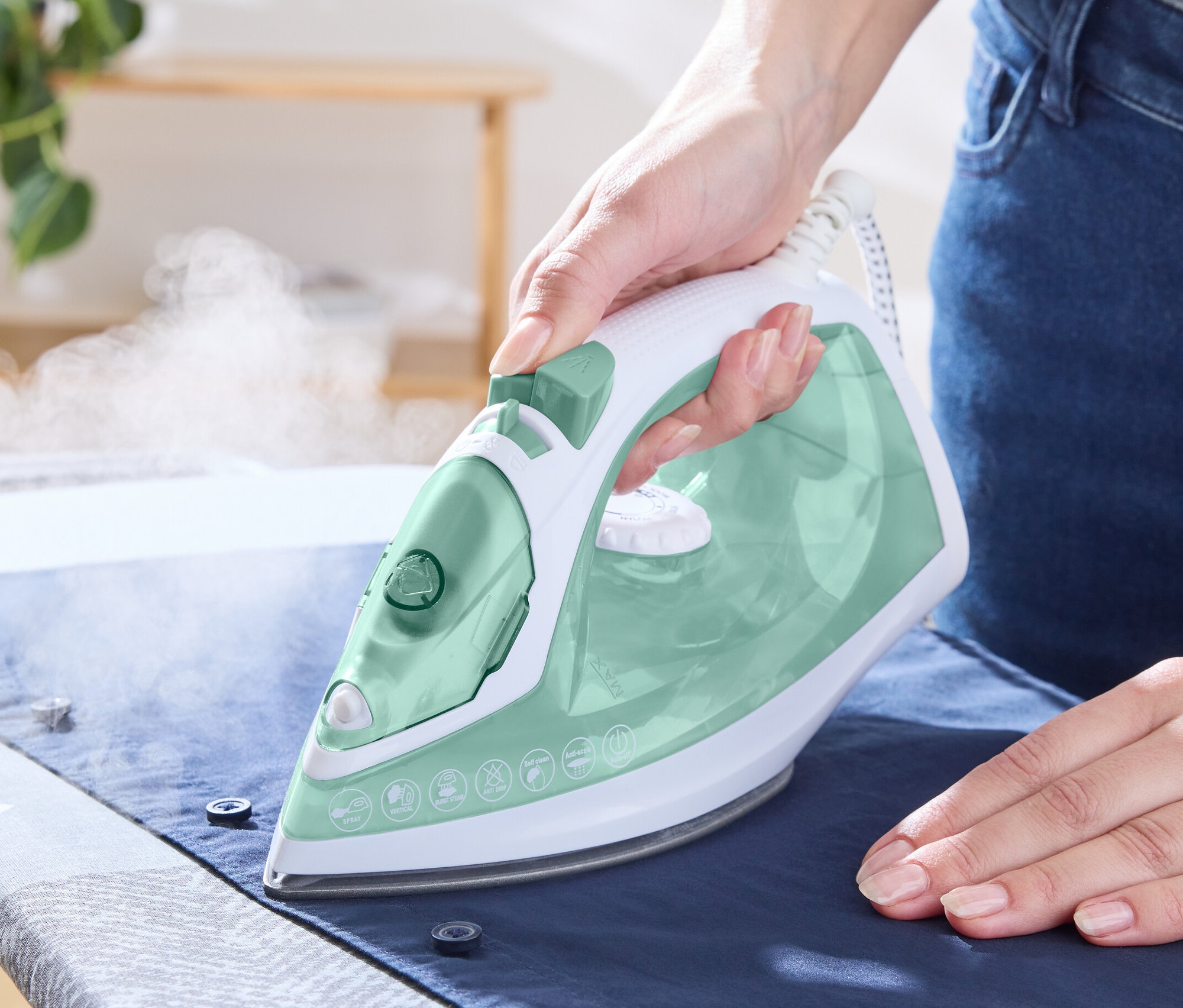 Žena žehlí košili napařovací žehličkou.