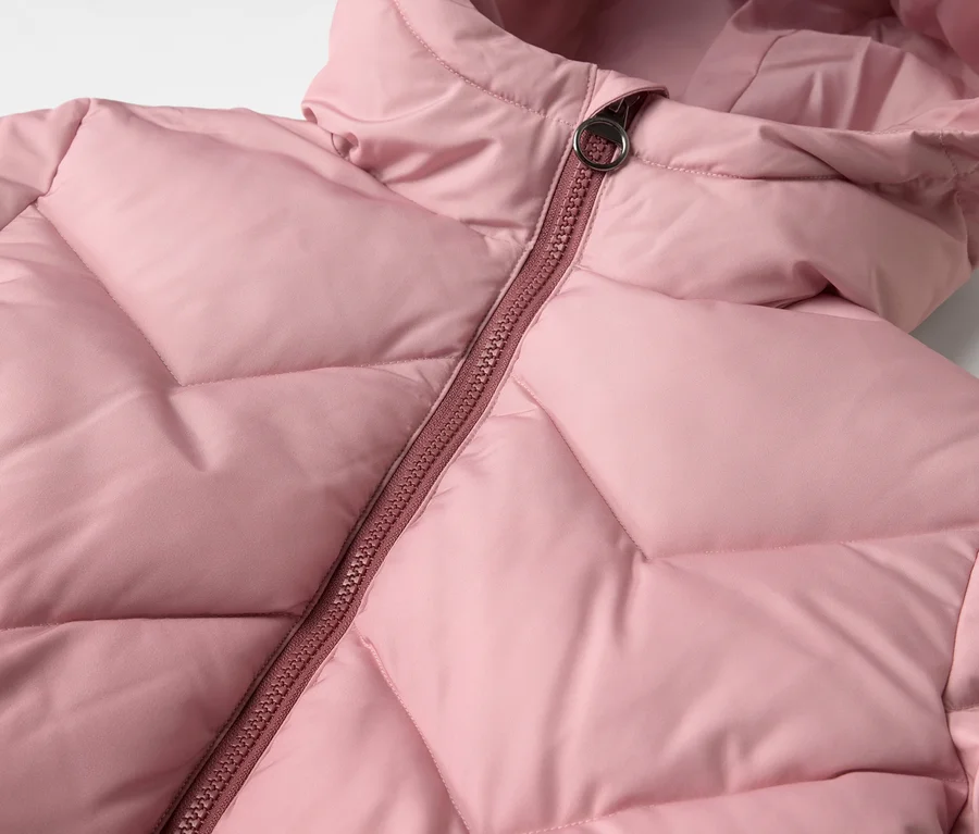 Detailní záběr na růžový dětský termo kabát s kapucí a zipem.