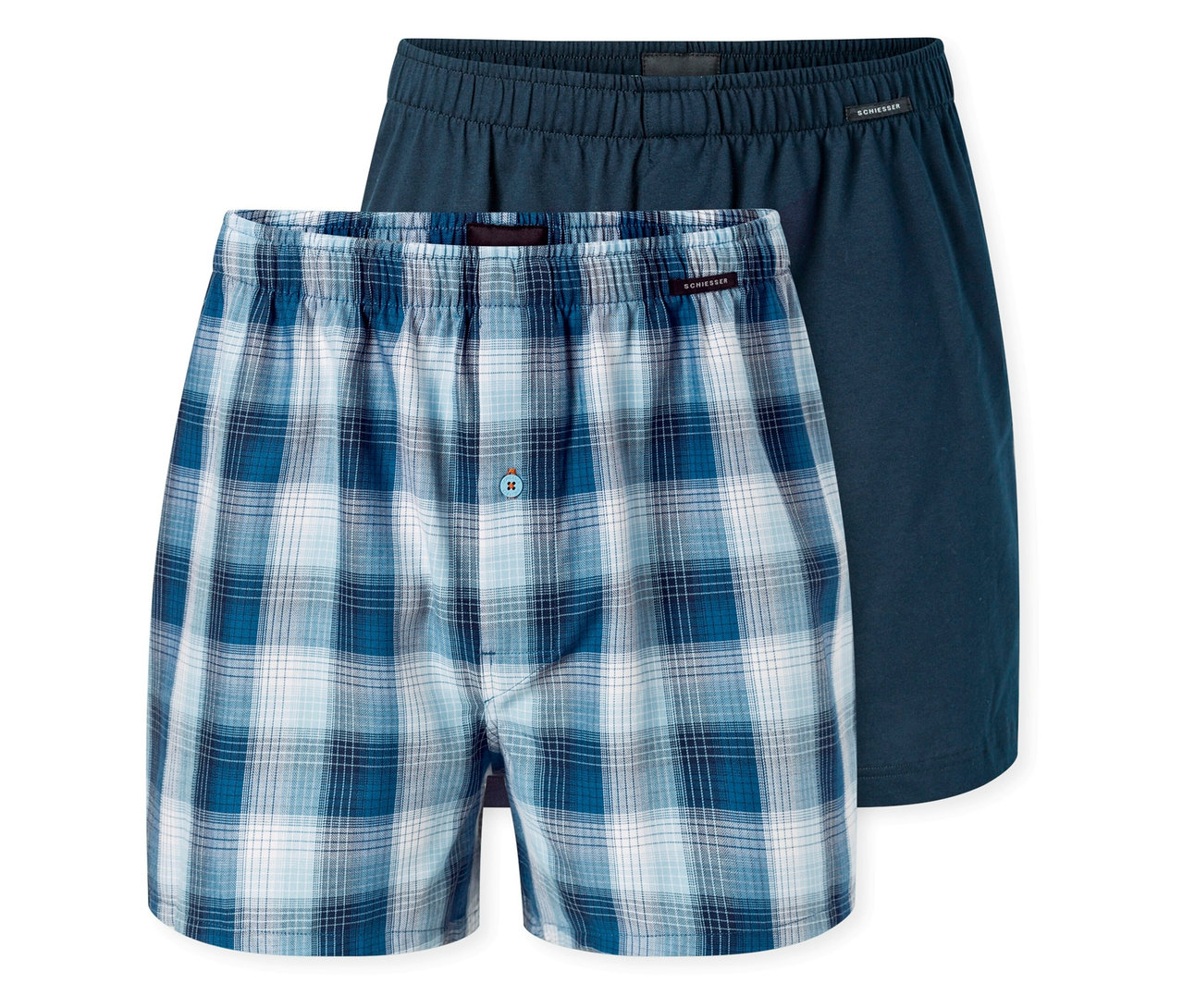 Dvoje boxerky, jedny modré kostkované, druhé tmavě modré, leží na sobě.