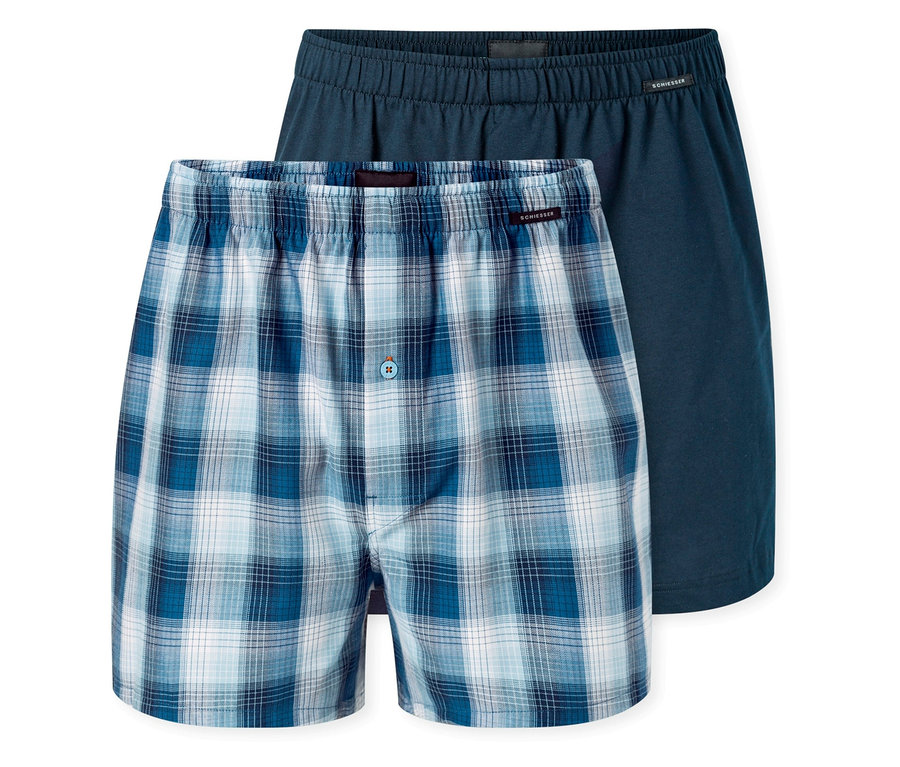 Dvoje boxerky, jedny modré kostkované, druhé tmavě modré, leží na sobě.